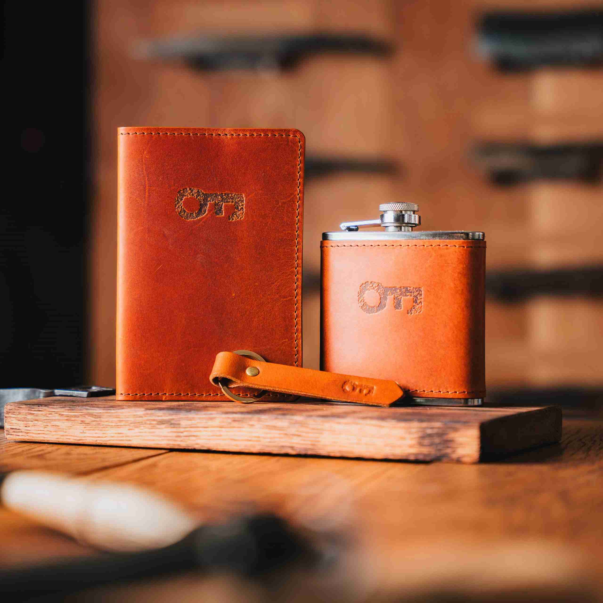 Leather branded passport holder, hip flask and key ring